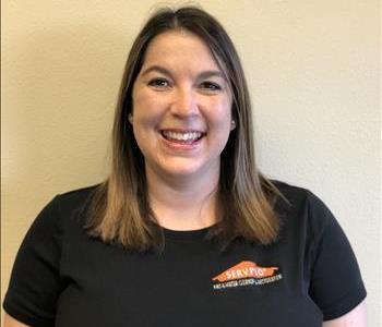 women in black SERVPRO shirt in front of a white wall 