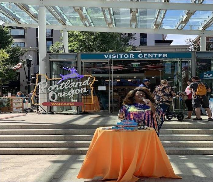 Poison Waters calling Bingo in front of Travel Portland's new location 